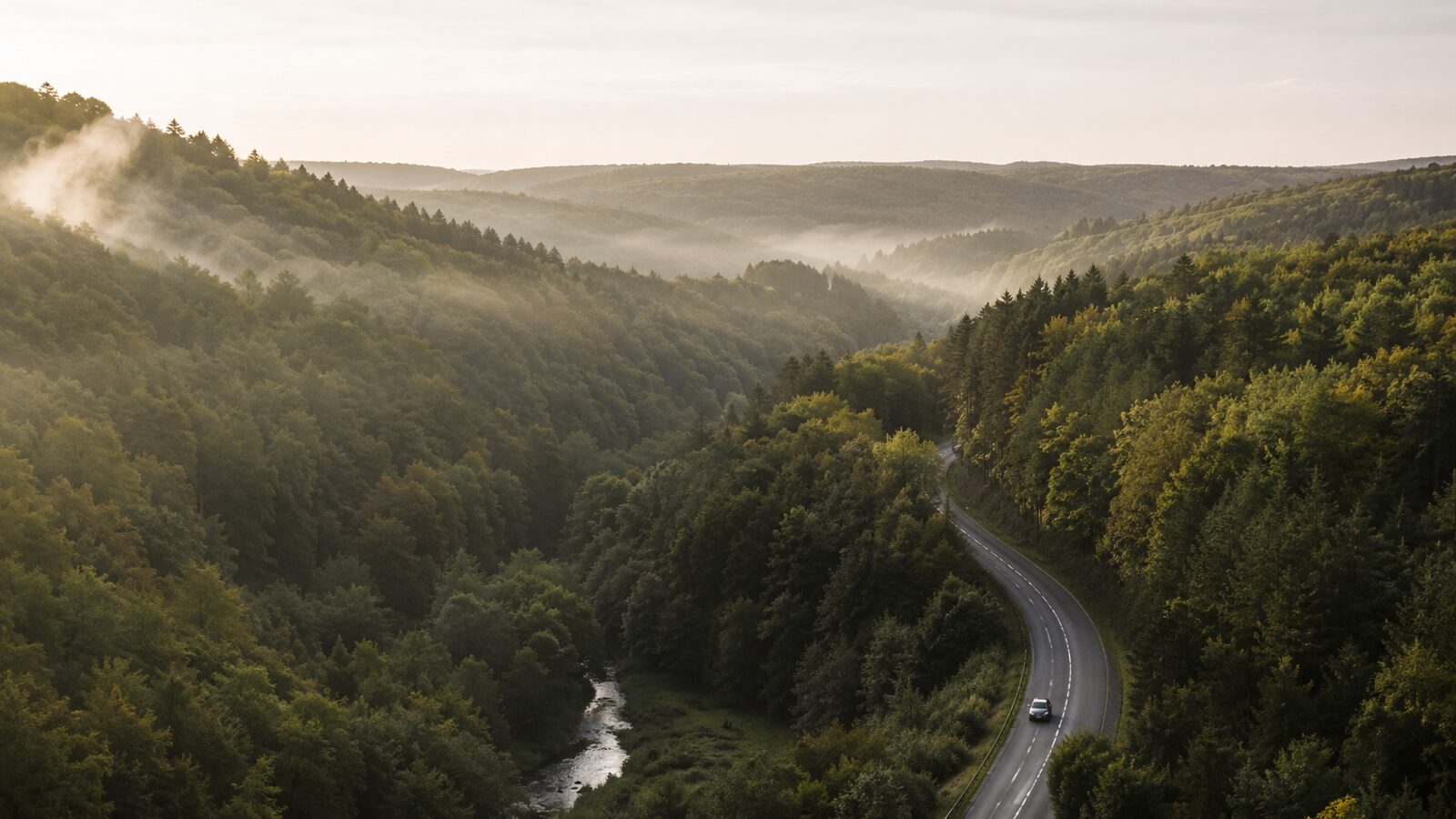Auto op een bochtige weg door de Belgische heuvels